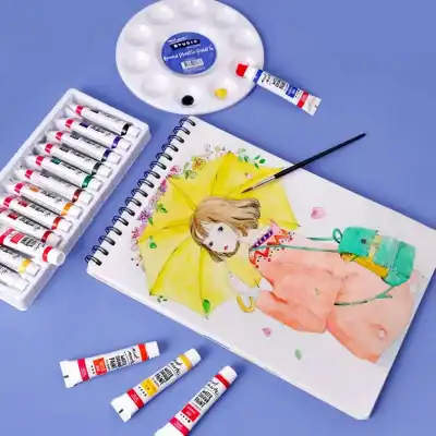 Brightly colored watercolor paints, sketchbook with an illustration of a girl holding a yellow umbrella, and art supplies on a pastel blue background, ideal for art and painting enthusiasts at Monalisa Store.