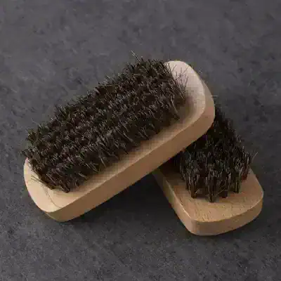 Shoe brush and suede cleaning tools for shoe care and maintenance, made of wood and metal bristles, ideal for polishing and restoring shoes.