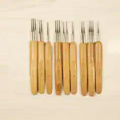 Tweezer set with wooden handles used for precise eyeglass repair and lens handling.