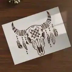Intricate black and white buffalo skull with feather and floral designs, art stencil for wall decor, ideal for bohemian or eclectic interior styles.