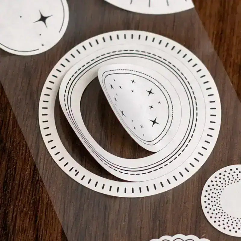 Delicate black and white starry sky designs on circular cutouts for skincare or beauty product packaging at Monalisa Store.