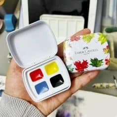Bright watercolor paint set with red, yellow, blue, and black colors in compact case for arts and crafts.