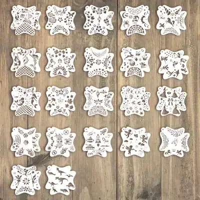 Delicate white paper snowflake cutouts with intricate holiday and winter-themed designs, perfect for Christmas decorations, arts and crafts, and festive home decor.