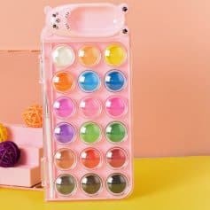 Multicolored lip balm set in a pink, bear-shaped storage case, perfect for lip care and beauty routines. Bright, fun design appeals to kids and adults alike.