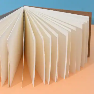 Deluxe photo album with cream pages open, smooth textured paper, ideal for storing photographs and memorabilia, displayed on orange surface with blue background.