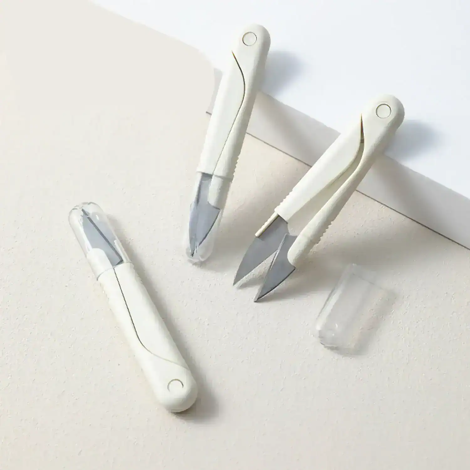 Precision surgical scalpels with white ergonomic handles, sterilized for safe medical procedures and dermatological treatments, displayed on a clean white surface.