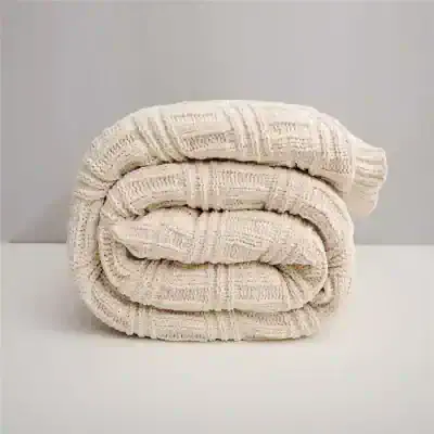 Ultra-soft knitted cream-colored blanket, cozy and stylish for home comfort and relaxation. Perfect for bedrooms or nurseries, adding warmth and aesthetic charm.