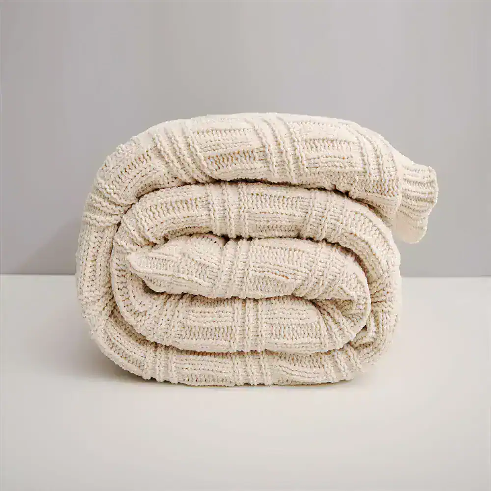 Ultra-soft knitted cream-colored blanket, cozy and stylish for home comfort and relaxation. Perfect for bedrooms or nurseries, adding warmth and aesthetic charm.