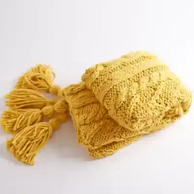 Soft yellow knitted blanket with tassels, ideal for baby or adult comfort, perfect for cozy home decor or gifting.