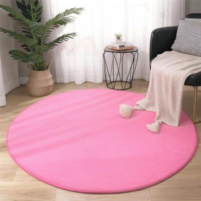 Pink round plush rug for modern interior decor, ideal for living rooms and bedrooms. Soft and stylish, perfect for adding warmth and color to your space.