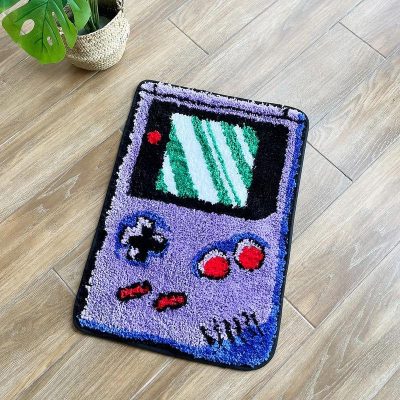 Video game controller-shaped doormat with pixel art design, vibrant colors, and soft textured surface for home decor and entrance welcome mats.