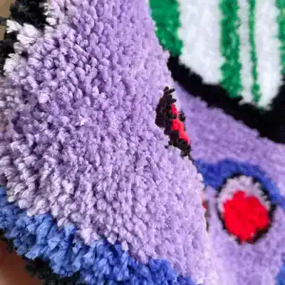 Bright purple and black ladybug on a soft, textured purple fabric. Perfect for adding a natural element to fashion, home decor, or craft projects. High-quality, vibrant, and detailed textile close-up.