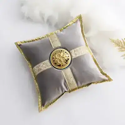 Luxurious silver and gold decorative pillow with ornate embroidery and a central medallion, ideal for elegant home decor and special occasions.