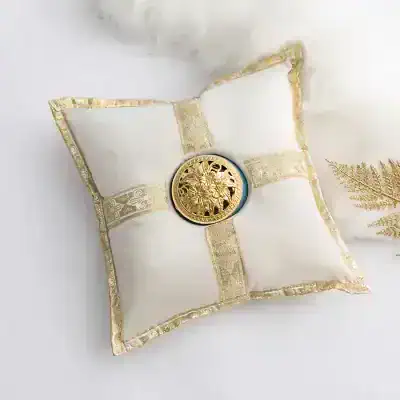 Vintage gold and white decorative pillow with ornate detailing and a central medallion, ideal for luxury home decor or special occasions.