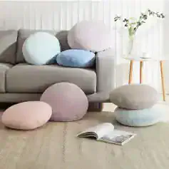 Soft pastel round cushions on a modern living room sofa with neutral tones and minimal decor, creating a cozy and stylish atmosphere for home comfort.
