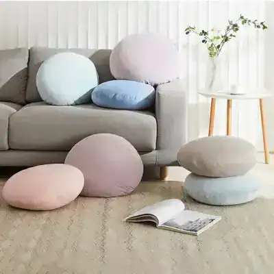 Soft pastel round cushions on a modern living room sofa with neutral tones and minimal decor, creating a cozy and stylish atmosphere for home comfort.