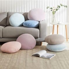Soft pastel-colored cushions on a beige sofa in a modern living room, perfect for comfortable seating and home decor.