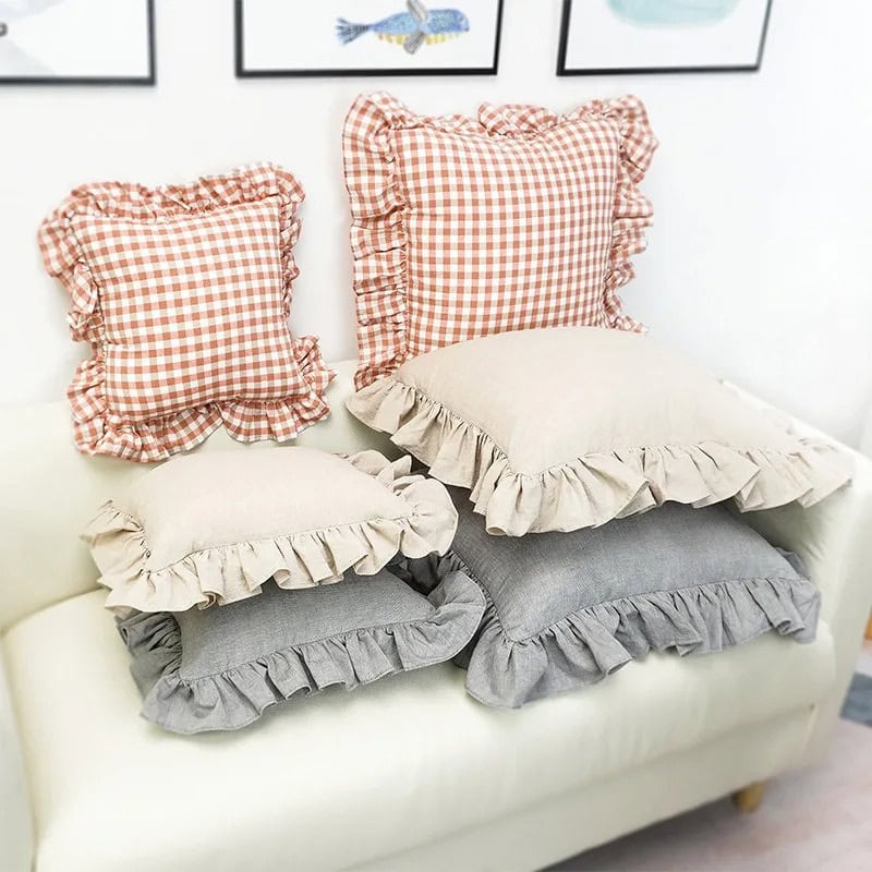 Soft throw pillows with ruffled edges in beige, gray, and gingham checkered patterns, perfect for cozy home decor and bedroom accents.