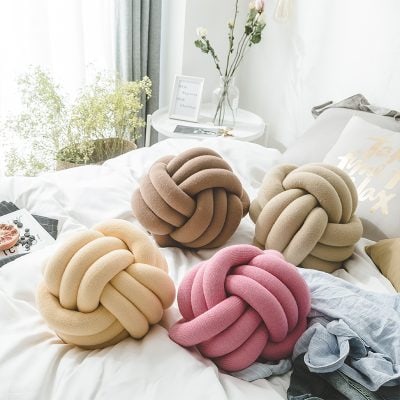 Knotted plush cushion collection in pink, beige, taupe, and cream, perfect for modern home decor and adding comfort to bedrooms or living spaces.