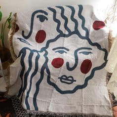 Vibrant monochrome abstract face blanket with red accents, ideal for home decor and cozy living rooms, inspired by modern art for stylish interior design.