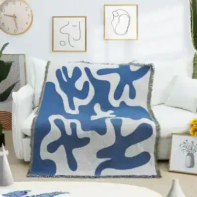 Soft blue and white abstract patterned throw blanket displayed on a modern white sofa, perfect for home decor and comfort at Monalisa Store.