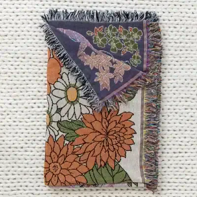 Vibrant floral tapestry featuring colorful embroidered flowers, with fringed edges, perfect for home decor or as a gift at Monalisa Medical Store.