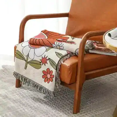 Vase-shaped floral blanket draped over mid-century modern wooden bench with armrests, perfect for home decor or sitting area.