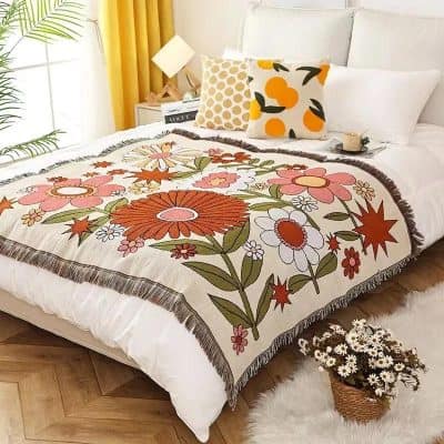 Vibrant floral embroidered blanket on a cozy bed with modern pillows in a bright bedroom setting. Perfect for adding color and warmth to your home decor.