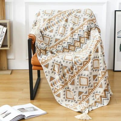 Luxurious geometric patterned throw blanket on modern living room chair, perfect for home decor and comfort, available at Monalisa Store.