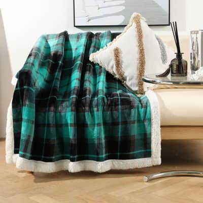 Cozy plaid throw blanket on cream sofa with decorative pillows, stylish home decor, perfect for maintaining warmth and comfort in a modern living room.
