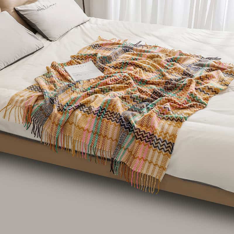 Colorful woven throw blanket on a bed, perfect for cozy bedroom decor and comfort, available at Monalisa Medical Store.
