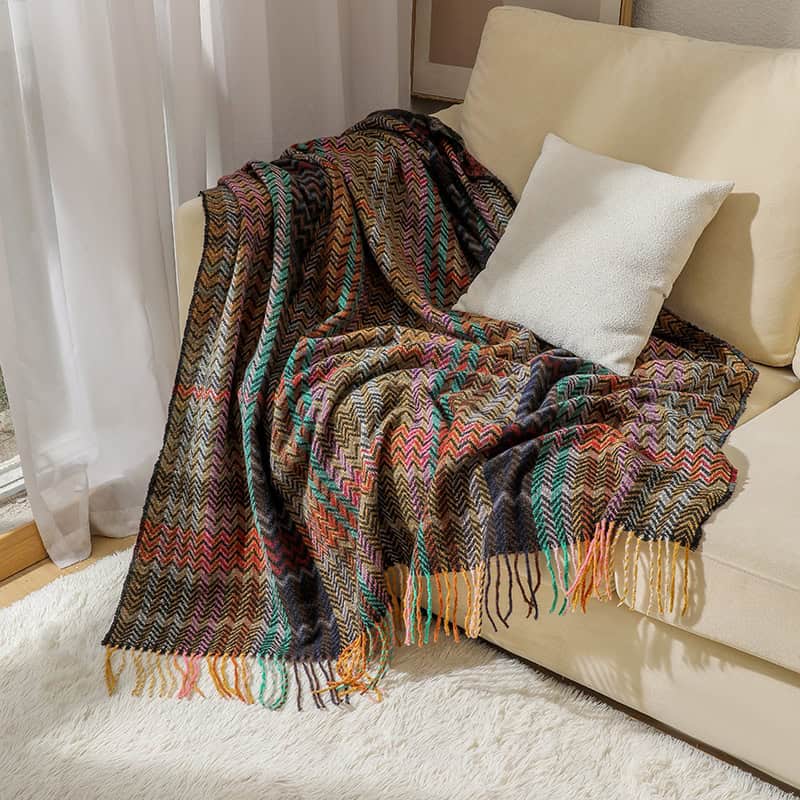 Beautiful multicolored woven throw blanket draped over cream sofa, perfect for cozy home decor. Adds vibrant style and warmth to any living space. Ideal for comfort, relaxation, and aesthetic enhancement.