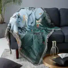 Intricate ocean-themed Merida tapestry draped over dark gray sofa, featuring mythical mermaids and sea creatures, ideal for home decor and adding a touch of fantasy.