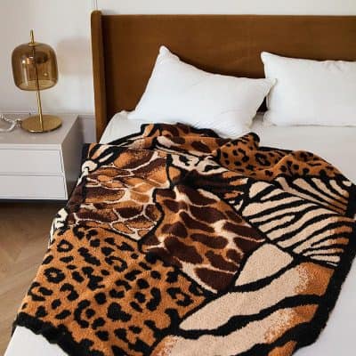 Luxurious animal print throw blanket on a cozy bed with white pillows, showcasing stylish bedroom decor. Perfect for adding warmth and exotic style to your sleep space.