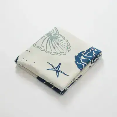 Soft white and navy beach towel with seashell and starfish print, ideal for pool or beach days, featuring high-quality fabric and vibrant marine-themed design.