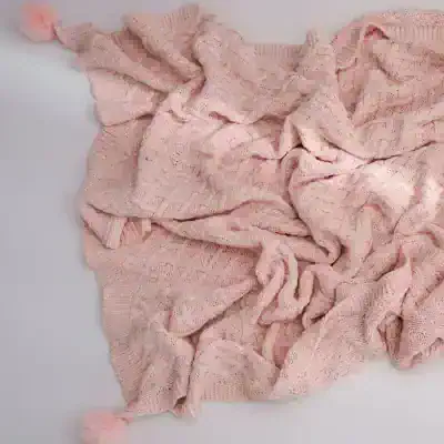 Luxurious pink knit throw blanket with intricate patterns, perfect for cozying up at home or as a stylish accessory for your living room or bedroom. Soft, warm, and high-quality for ultimate comfort.