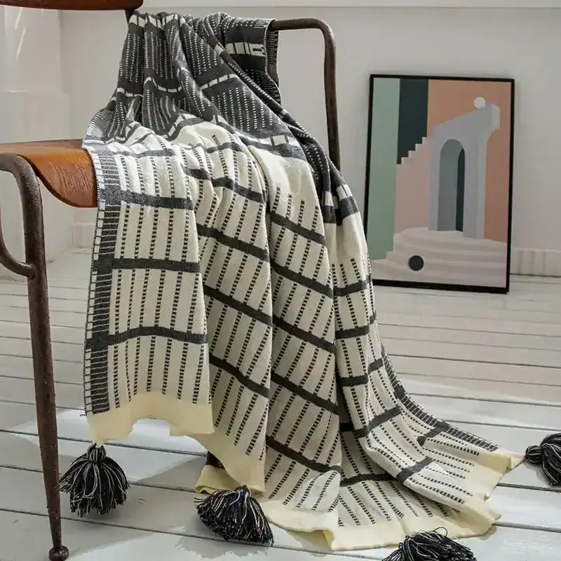 Luxurious black and white patterned throw blanket with tassels, perfect for home decor or cozying up in style.