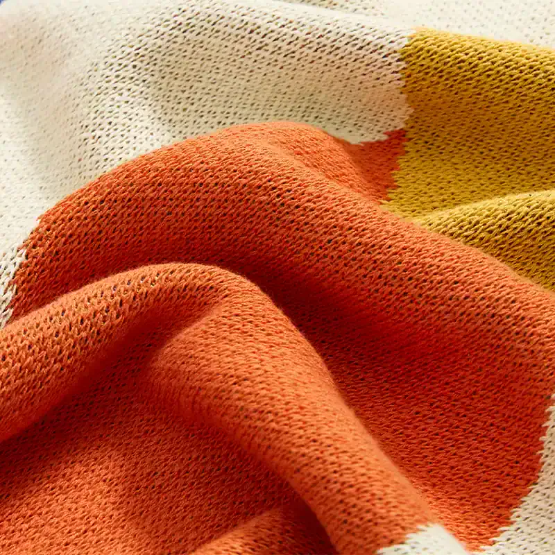 Soft-knit multicolor cotton fabric in orange, yellow, white, and beige, ideal for comfortable clothing and accessories.