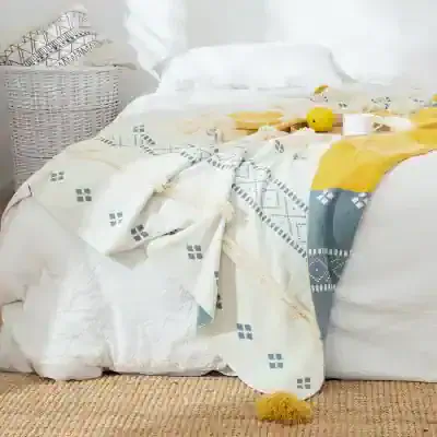 Linen bedding with geometric patterns and a yellow throw on a cozy bed, perfect for enhancing bedroom decor with stylish, high-quality sleep accessories from Monalisa Store.