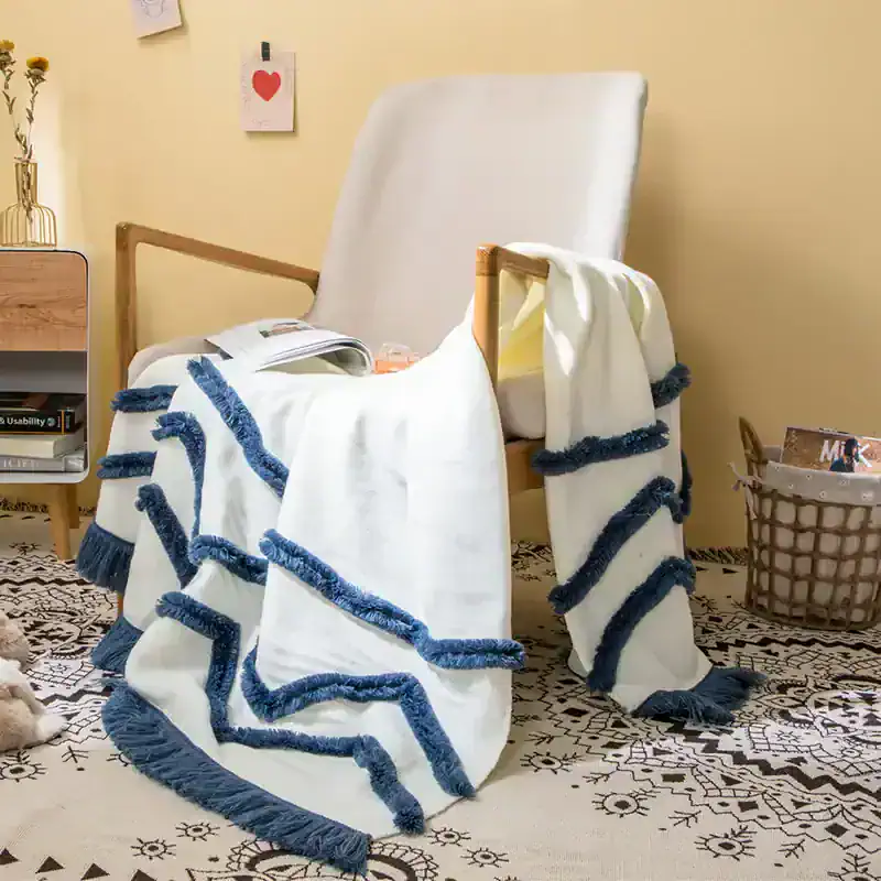 White and blue cozy throw blanket with tassels on a wooden armchair, modern home decor, Monalisa Medical store, stylish furniture, relaxed living space, comfortable textiles for home, contemporary interior accessories, elegant room design, bedroom or living room setup, decorative home accents.