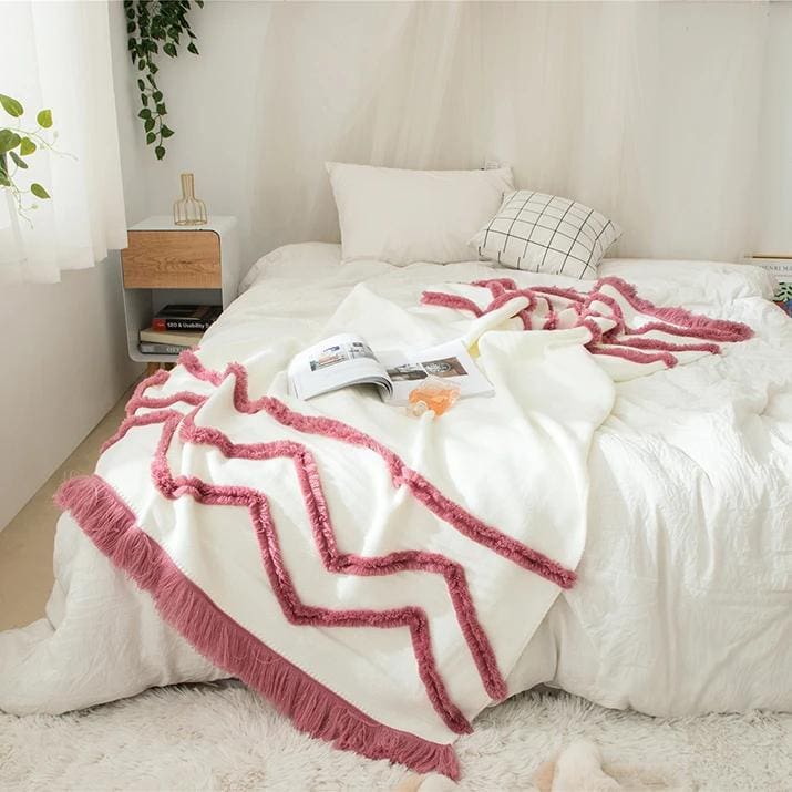 Pink and white cozy blanket with fringes on a neatly made bed in a bright bedroom, Monalisa Store, home decor, and interior design for comfort and style.