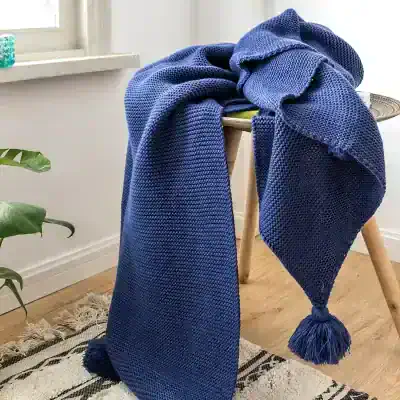 Warm blue knitted throw blanket with tassels, perfect for cozying up or home decor. Made of soft, high-quality wool for comfort and style. Ideal for sofas or beds.