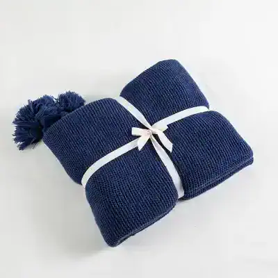 Comfortable navy blue knit hat with pom-poms, perfect for cold weather. Stylish and cozy winter accessory for men and women.