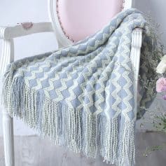 Luxurious knitted throw blanket with zigzag patterns, soft textures, and fringed edges, perfect for enhancing the aesthetic of medical or beauty spa spaces at Monalisa Store.