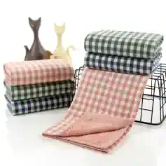 Soft checkered towels in pastel pink, green, and navy blue, displayed in a stylish setting, perfect for home or bathroom decor.