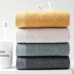 Soft-colored plush towels stacked neatly, ideal for home or spa use. Perfect for relaxation and comfort, these high-quality towels are stylish and absorbent, enhancing your bathroom decor.