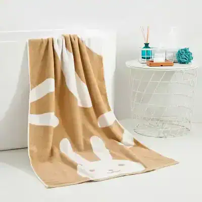 Soft beige and white bunny-themed plush blanket draped over a white surface, perfect for cozy opt therapy or relaxation.