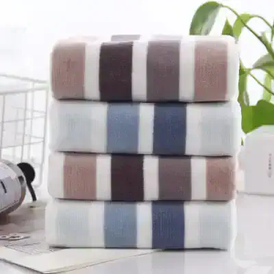 White and pastel-colored striped towels stacked on top of each other, cozy home accessories, soft texture, Monalisa Store, premium quality towels for home comfort and elegance.