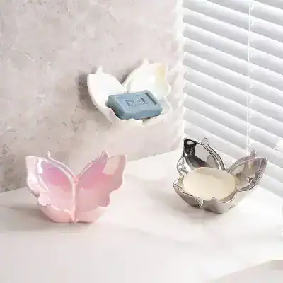 Tiled butterfly-shaped soap holder and soap dish on a modern bathroom countertop with window blinds, stylish and functional decor for soap and toiletries.
