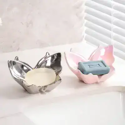 Silver and pink ceramic flower-shaped bowls for storing cosmetics and skincare products.